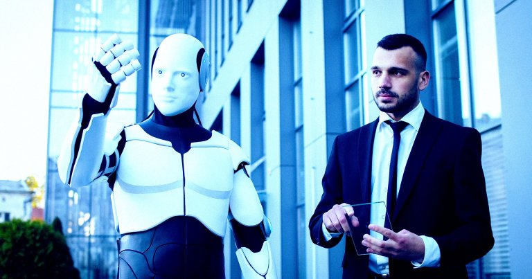 A man in a suit walking next to a humanoid robot.