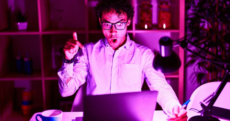 A color-treated photo of a man staring at a laptop.
