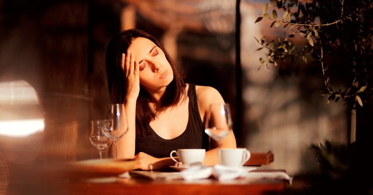 A woman looking bored during a date at a restaurant.
