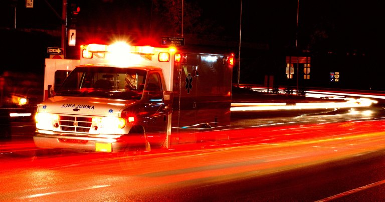 Ambulance standing in night traffic at a motor vehicle accident.