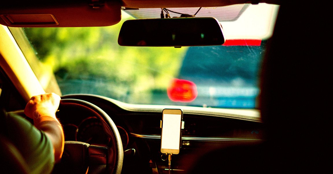 A shot of a man driving with a smartphone.