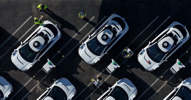 In an aerial view, Waymo robotaxis sit parked at a Waymo facility.