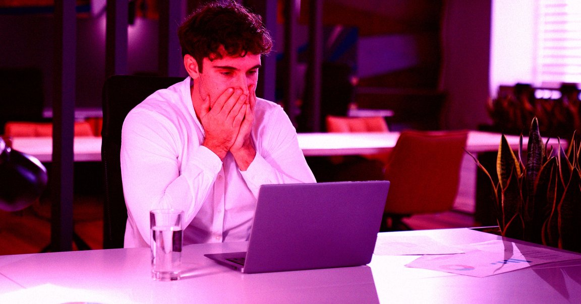 A man shocked while looking at his laptop.