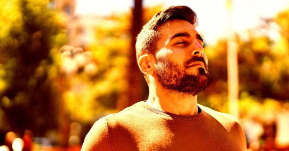 A color-treated photo of a man breathing in deeply.