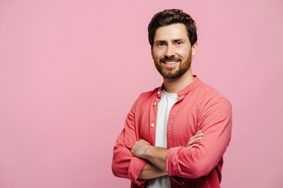 A confident-looking man smiles into the camera.