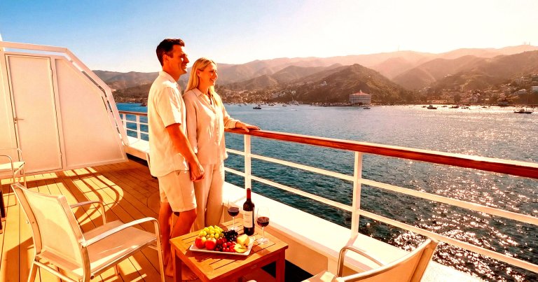 A couple standing on the deck of a cruise ship.