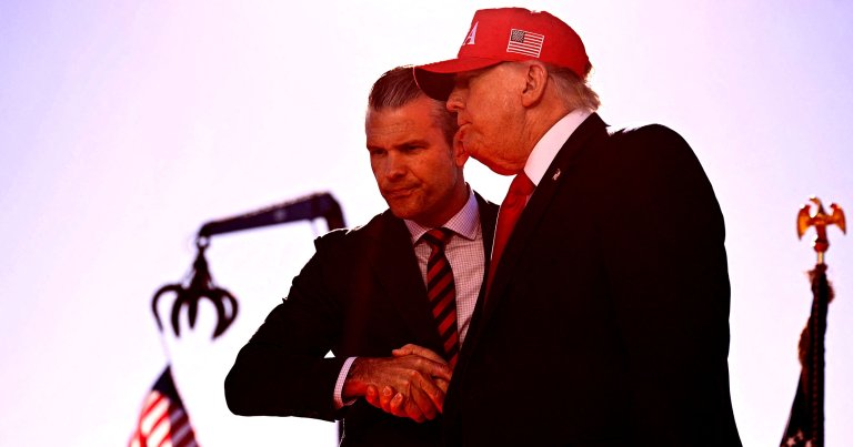 US President Donald Trump (R) shakes hands with Secretary of Defense Pete Hegseth as he arrives to speak at Anduril Industries.