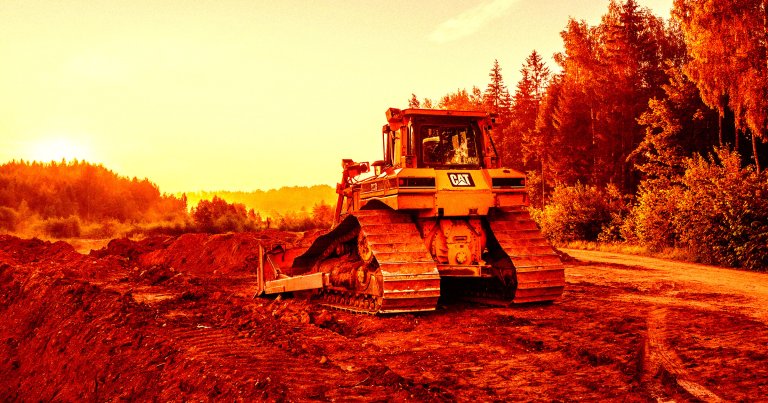 A color-treated photo of a bulldozer near a forest.