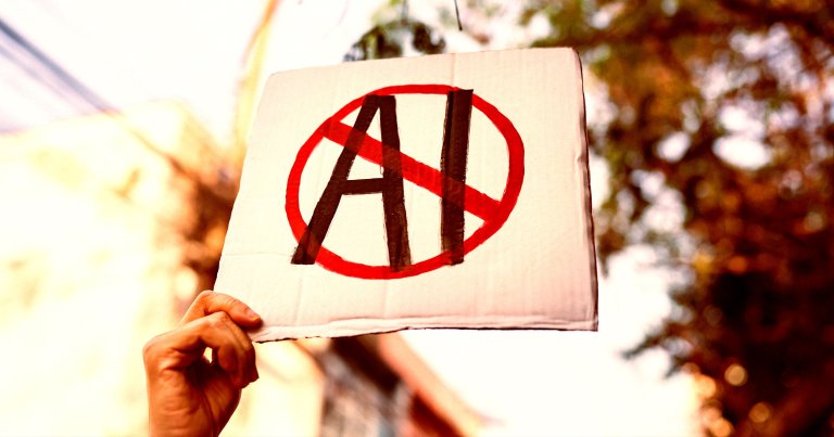 A demonstrator holding up a sign with the letters AI crossed out.