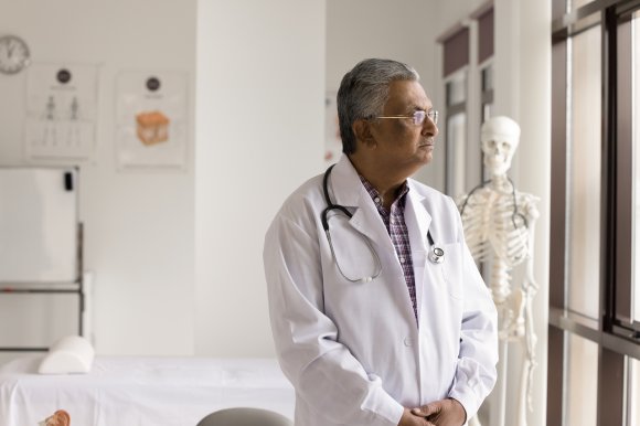 A photo shows an older doctor looking thoughtful.