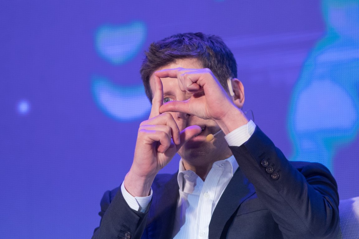 OpenAI CEO Sam Altman is shown gesturing with his hands.