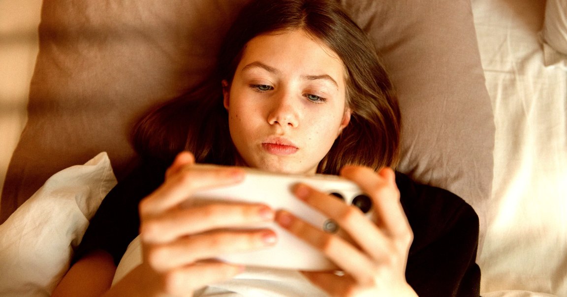 A young girl looking at a smartphone.