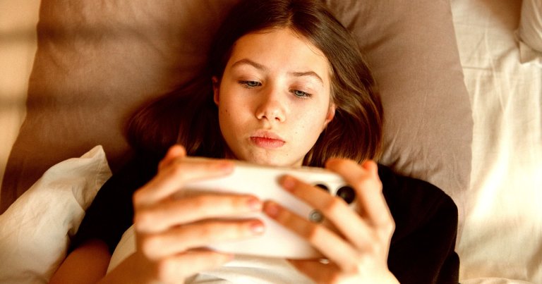 A young girl looking at a smartphone.