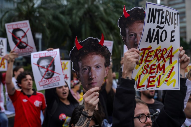 Demonstrators wear masks depicting Meta CEO Mark Zuckerberg, Brazilian presidential candidate Flavio Bolsonaro and US President Donald Trump during a protest outside Meta's headquarters in Sao Paulo, Brazil.