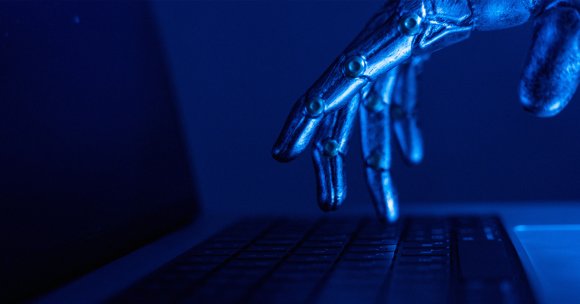 A robot finger hovering over a keyboard.
