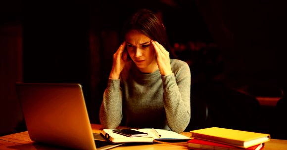 An upset student looks at a laptop.