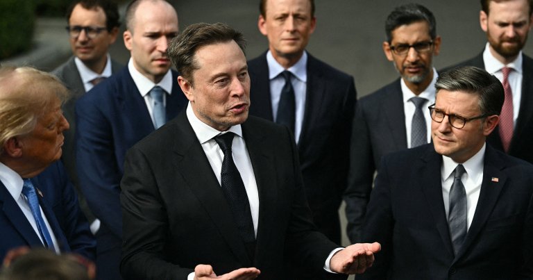 US President Donald Trump and US Speaker of the House Mike Johnson (R) look on as CEO of Tesla and SpaceX Elon Musk speaks to the press.