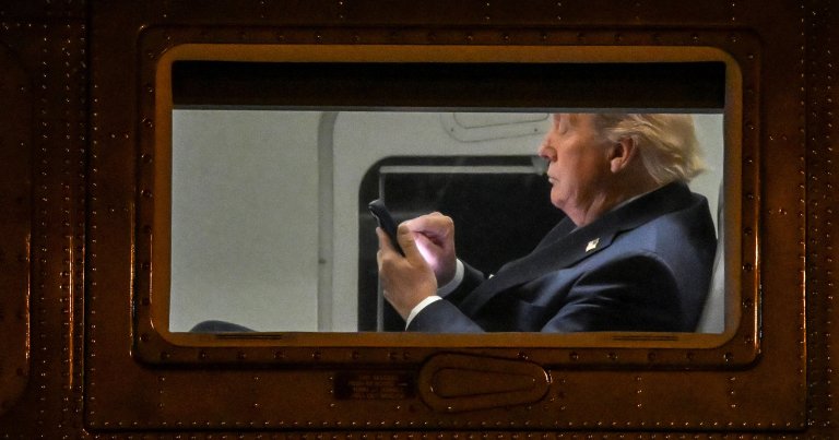 US President Donald Trump uses a cellphone aboard Marine One before it departs.
