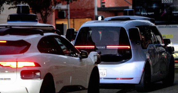 An automobile operating under Alphabet's Waymo autonomous driving technology navigates a city street.