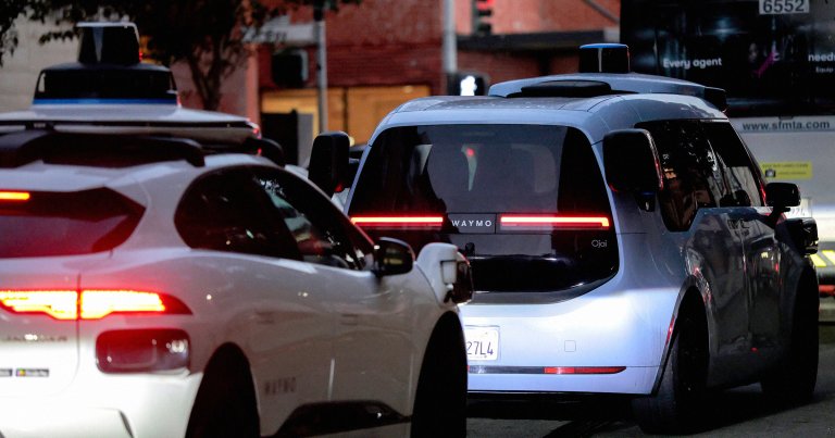 An automobile operating under Alphabet's Waymo autonomous driving technology navigates a city street.