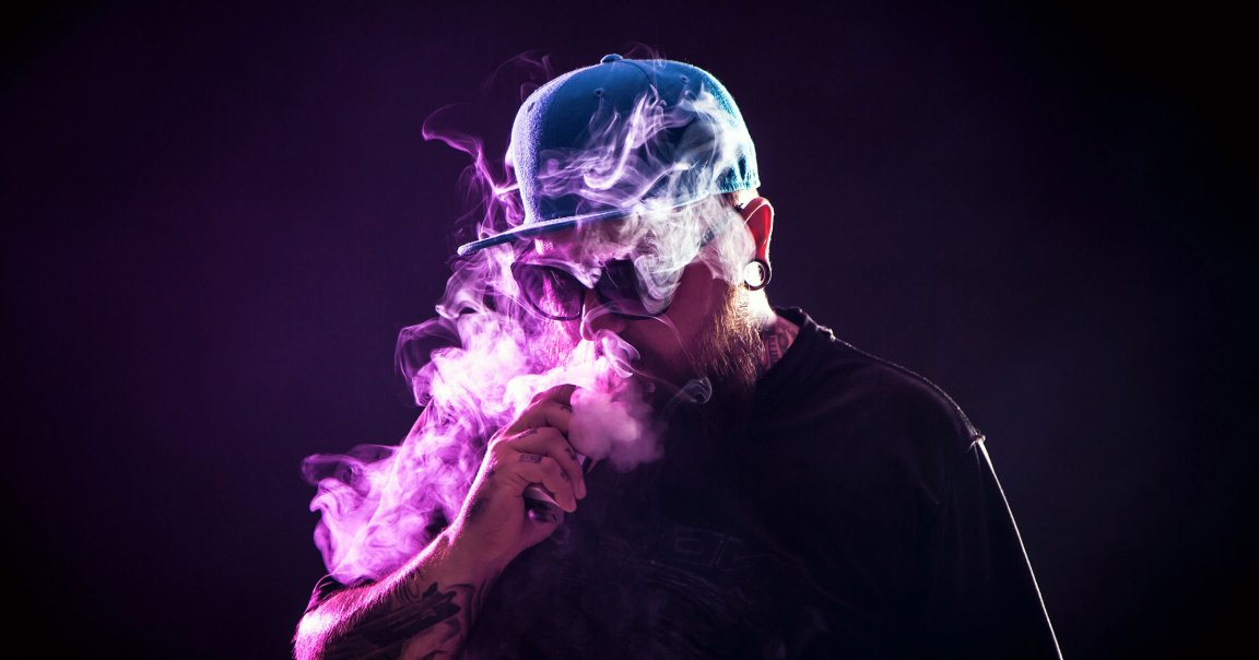 A color-treated photo of a man vaping.
